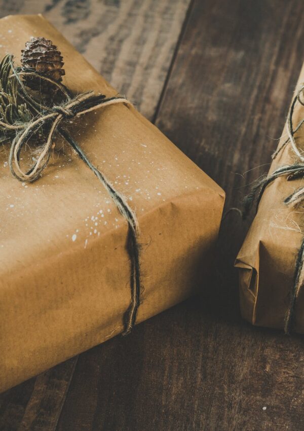 photo of two brown wrapped gifts on wooden table